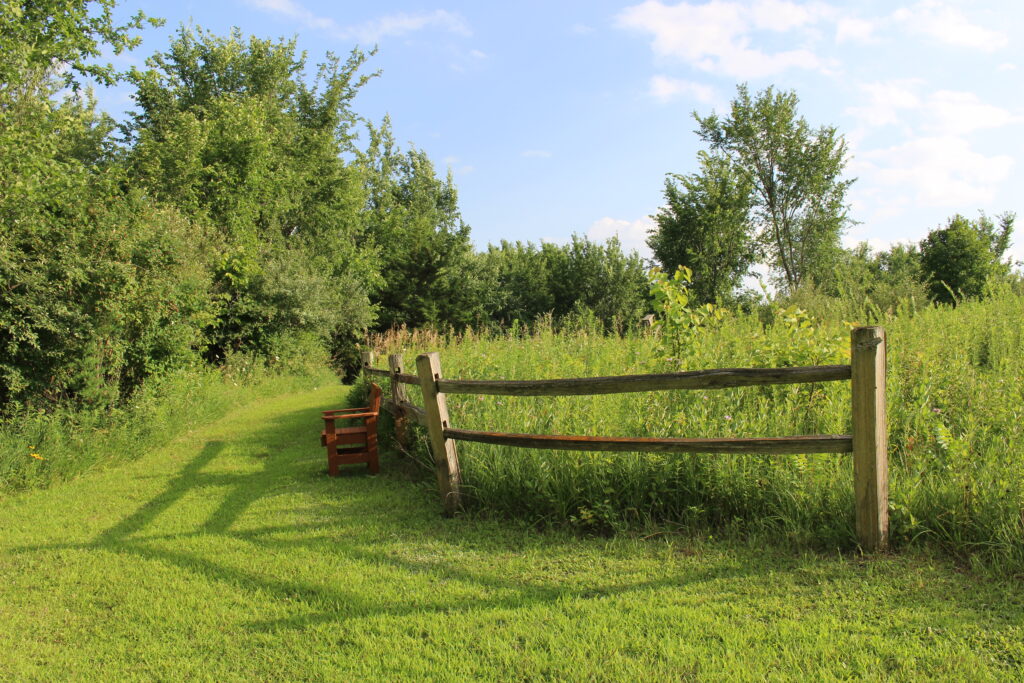 Path rounding a fenced corner of the upper prairie.