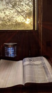 Bible opened to Psalms on table below sunlit window of the Granary.